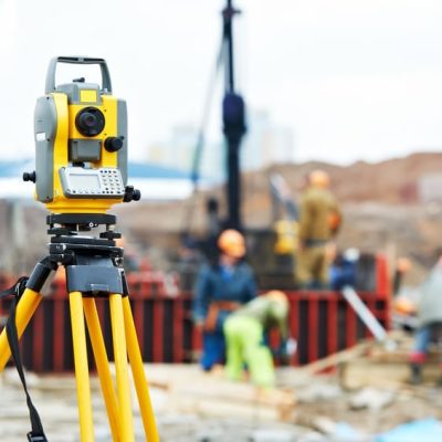 Surveying measuring equipment theodolite transit on tripod at construction building area site